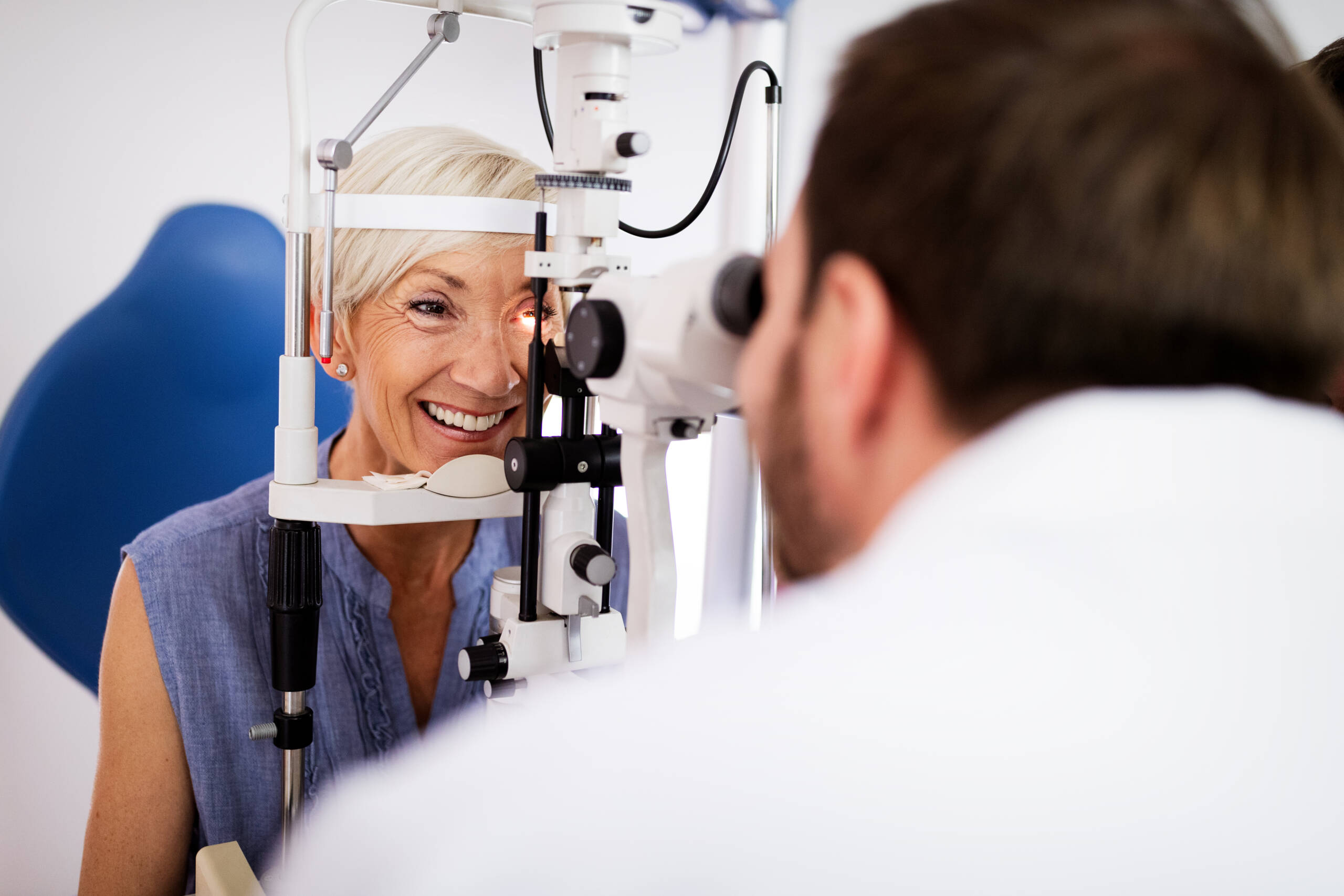 Optometrist examining senior woman in modern ophthalmology clinic